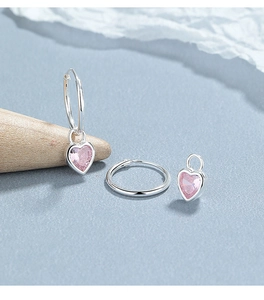 Macro shot of 925 sterling silver hoop earring with detachable pink heart zircon pendant