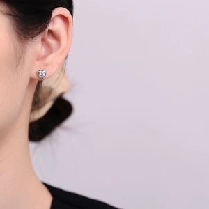 Minimalist 925 sterling silver heart stud earrings with cubic zirconia on model