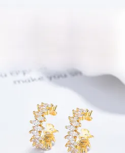 Gros plan de créoles en C en argent 925 avec zircons marquise et placage en or épais