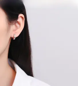 Detailed close-up of 925 sterling silver woven earrings with sparkling micro-diamonds