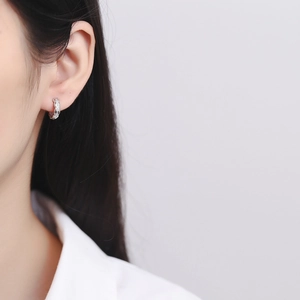 Elegant 925 sterling silver hoop earrings with pave diamonds on model's ear