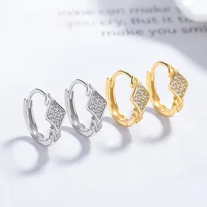 Close-up of geometric diamond-shaped hoop earrings with micro-pave cubic zirconia stones