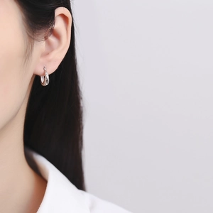 Boucles d'oreilles créoles en argent 925 avec texture martelée portées par mannequin