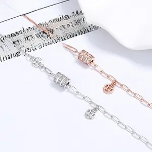 Detailed macro view of silver and rose gold link necklaces with pavé zircon cylinder pendants