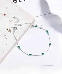 Macro shot of 925 sterling silver box chain bracelet with emerald green crystals