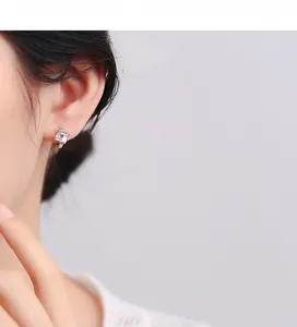 Détail de boucles d'oreilles en argent 925 avec zircons portées par un mannequin