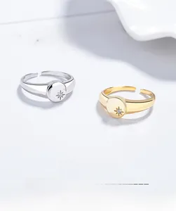 Detail of silver and gold starburst rings with inlaid rhinestone and adjustable band