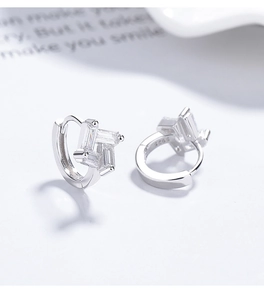 Vue macro de créoles en argent sterling 925 avec des pierres de zircon carré géométriques