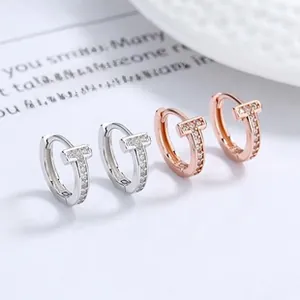 Détail de boucles d'oreilles en T argent et or rose avec incrustation de micro-zircons