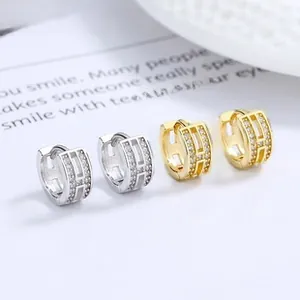 Vue macro des boucles d'oreilles créoles en argent 925 doré et argenté avec zircons pavés