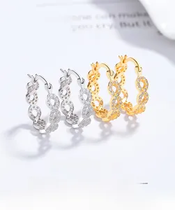 Détail de boucles d'oreilles signe infini avec zircons en finitions or et argent