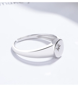 Close-up of silver signet ring featuring an eight-point star with a small zircon center