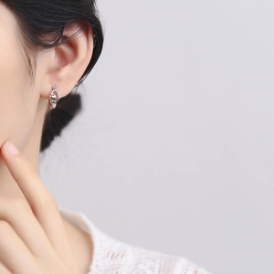 Elegante Herz-Ohrringe aus 925er Sterlingsilber mit Zirkonia-Steinen an einem Model getragen