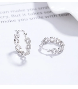 Détail macro de boucles d'oreilles infini en argent 925 avec pavé de zircons blancs