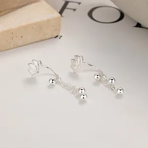 Detail of 925 silver lotus stud earrings with delicate metal tassel and bead drops