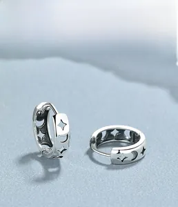 Macro detail of S925 sterling silver hoop earrings with hollow star and moon patterns