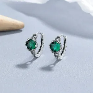 Macro shot of S925 sterling silver hoop earrings with vintage green emerald stones