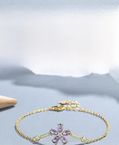 Dettaglio macro del bracciale in argento S925 placcato oro con fiore viola e zirconi