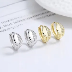 Detail view of gold and silver hoop earrings with micro-pave cubic zirconia and leaf patterns
