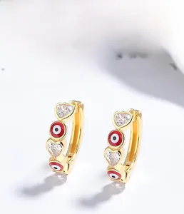 Détail macro de boucles d'oreilles cœur en argent 925 plaqué or avec œil et zircons