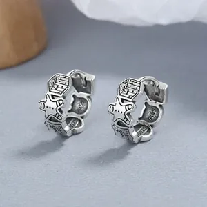 Detailed macro view of S925 sterling silver vintage hoop earrings with cartoon carvings