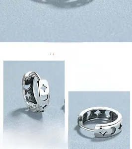 Close-up of S925 sterling silver hoop earrings with hollow star and moon patterns
