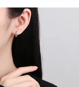 Detailed view of model wearing hollow star and moon 925 silver hoop earrings