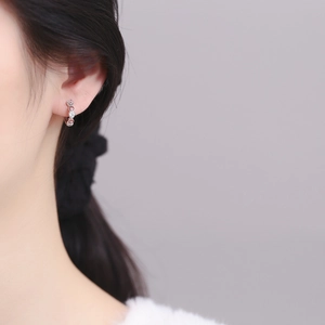 Boucles d'oreilles cœur en argent 925 avec charms œil grec portées sur modèle