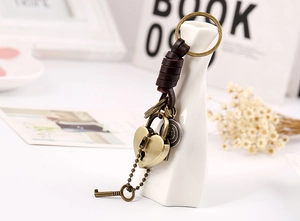 Detail of vintage heart lock and key keychain with braided brown leather rope