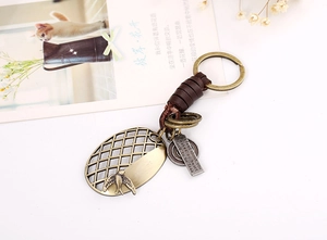 Detail of vintage leather keychain featuring alloy swallow charm and engraved pendant