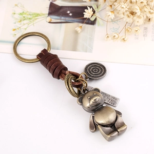 Retro bronze bear leather keychain with engraved tag on a minimalist white background