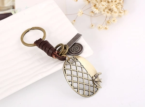 Detail of vintage leather keychain with bronze swallow charm and engraved metal tag