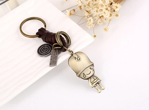 Retro bronze metal soldier charm and deep brown woven leather keychain on a white tray