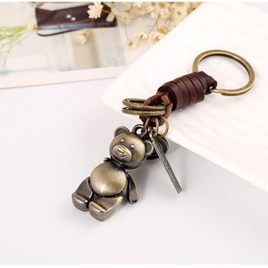 Retro bronze bear keychain with dark brown braided leather strap and metal tag