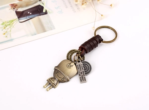 Macro view of vintage bronze alloy keychain with woven leather and engraved figurine