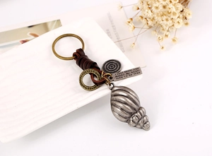 Macro d'un porte-clés en cuir punk avec breloque conque et étiquette gravée