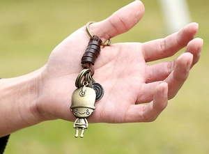 Close-up of vintage bronze soldier pendant with braided brown leather keychain