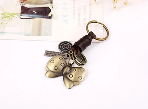 Macro view of vintage butterfly pendant with leather wrap and engraved bronze metal plate