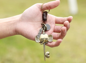 Detailed close-up of retro elephant alloy keychain with woven leather strap and heart charms
