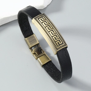 Detailed macro view of black leather bracelet with bronze Greek fret pattern inlay