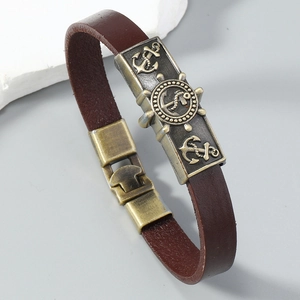 Macro view of vintage brown leather nautical bracelet with bronze anchor and helm buckle