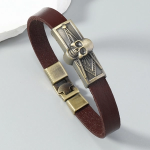 Gros plan d'un bracelet en cuir pour homme avec tête de mort en bronze et cuir texturé