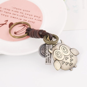 Vintage braided leather keychain with bronze owl pendant and engraved metal plates