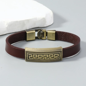 Macro detail of dark brown leather bracelet with bronze Greek Key pattern metal plate