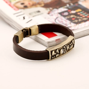 Macro shot of retro leather bracelet showing skull charms and bronze buckle details