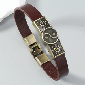 Macro detail of leather bracelet with bronze Tai Chi Eight Trigrams metal plate