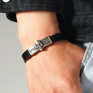 Détail d'un bracelet en cuir pour homme avec relief de crâne en bronze sur le poignet