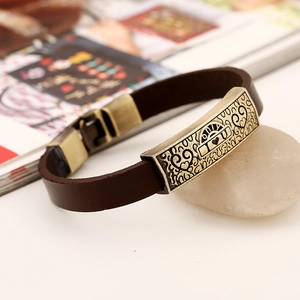 Detail of vintage brown leather bracelet with bronze heart charm and I Love U engraving