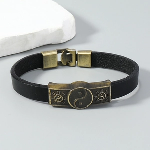 Macro detail of vintage leather bracelet featuring Tai Chi Yin Yang and Bagua bronze charms