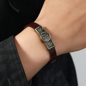 Retro brown leather bracelet featuring an antique bronze Tai Chi Bagua metal emblem